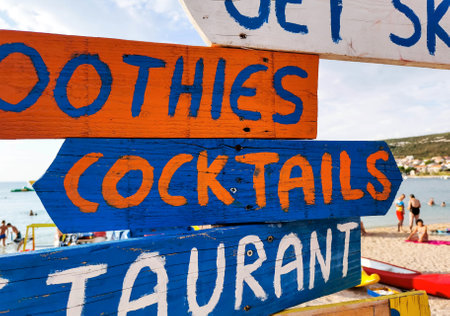 Colorful wooden direction signs with the writings smoothies, cocktails, restaurant at the beach