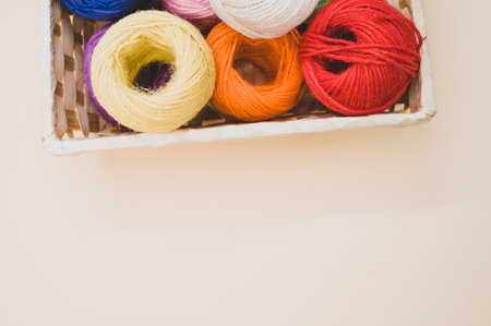Colorful thread rolls in a box isolated on a beige backgroundの写真素材