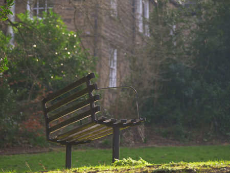 Park bench seating covered in cobweb with Covid in UK lockdown wide shot
