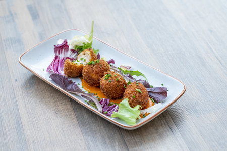A dish with delicious cheese balls and salad