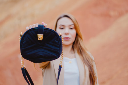 A selective focus shot of a female holding a blue purse to the cameの写真素材