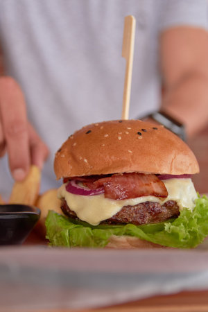 A vertical shot of big juicy burger with bacon and melted pepper jack cheeseの写真素材