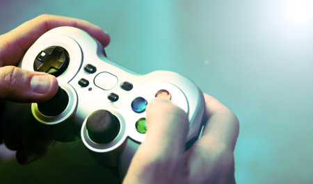 A person holding a video game controller and playing video gamesの写真素材