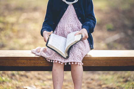 A little caucasian Christian girl reading the holy bibleの写真素材
