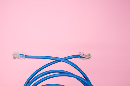 A top view of a blue LAN cable isolated on a pink backgroundの写真素材