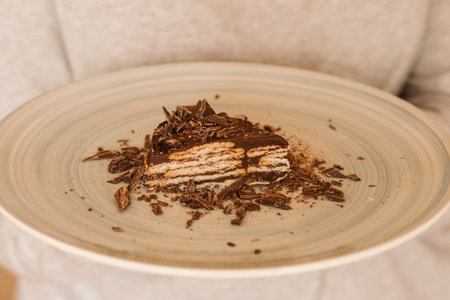 Man holding a piece of chocolate and biscuit cake. Homemade cake. Traditional birthday cake.の写真素材