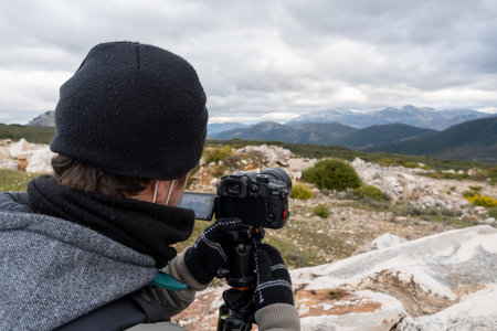 Stock photo of unrecognized photographer taking photos in the countryside.