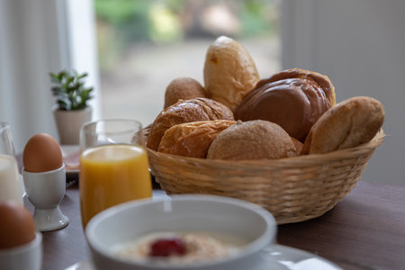 A selective focus shot of Breakfast set, crispy bread in a bamboo dish with an egg and orange juiceの写真素材