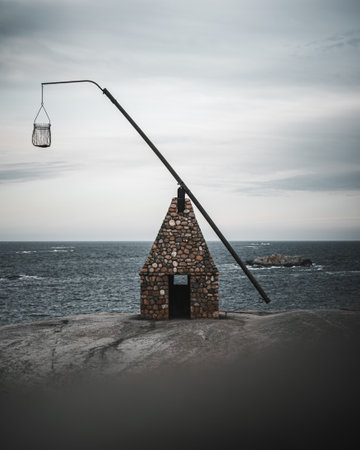 A vertical shot of an old stone lighthouse at Verdens Ende, Norway on a gloomy dayの写真素材