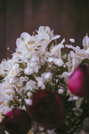 A vertical shot of white lilies with red roses as an interior decorationの写真素材