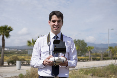a caucasian student from an aviation school with the command of a drone in hand during a drone...