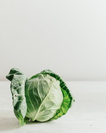 A closeup shot of fresh green cabbage with water droplets on it isolated on a white backgroundの写真素材