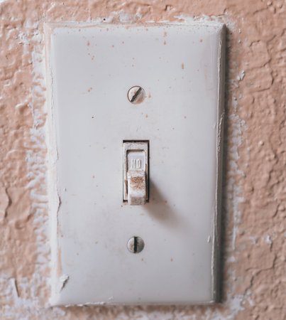 A vertical shot of an old light switch on the painted wallの写真素材