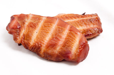 A closeup shot of smoked chicken breast isolated on white backgroundの写真素材