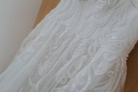 A closeup shot of a beautiful white wedding dress with pearls and beadsの写真素材
