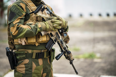 A shallow focus of a special force soldier holding his gun outdoors with a blurry backgroundの写真素材