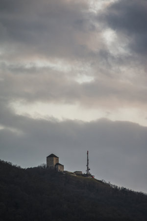 A scenic view of buildings and structures on top of a mountain under a gloomy skyの写真素材