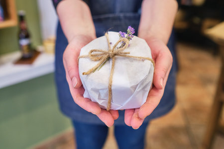 A selective focus shot of a pair of hands holding a gift item at a shopの写真素材