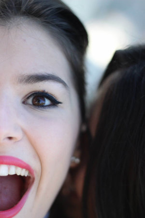 A vertical shot of the face of a young caucasian female with an open mouthの写真素材