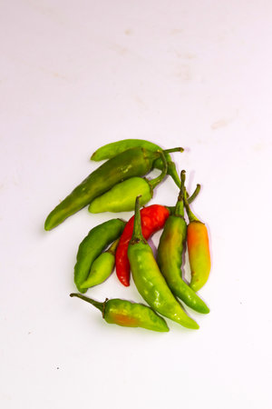 A top view of a heap of colorful hot chili peppers isolated in the light background