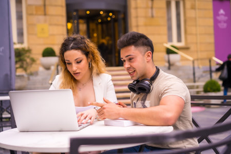 Young Spanish couple of entrepreneurs working with a computer - the concept of teamworkの写真素材