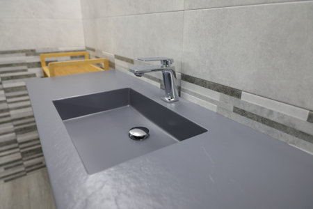 A closeup shot of a brand new silver sink in a renovated bathroomの写真素材