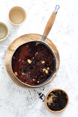Top View of chai Latte in a pot with spices: cloves and cardamom