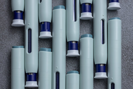 Abstract closeup of organized syringe self application pens on rustic gray kitchen counter background.の写真素材