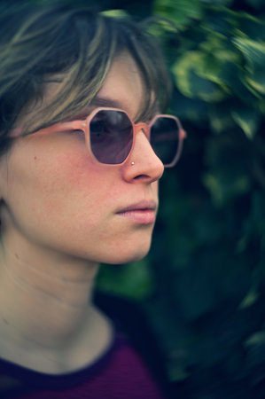 vertical swallow focus  shot of young female with pink sunglassesの写真素材