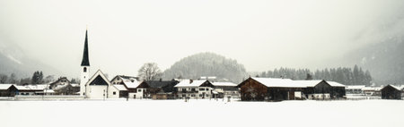 A panoramic shot of a winter village under snowfallの写真素材