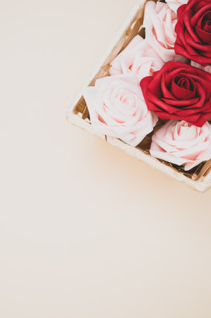 A vertical shot of beautiful red and white roses in a box isolated on a beige backgroundの写真素材