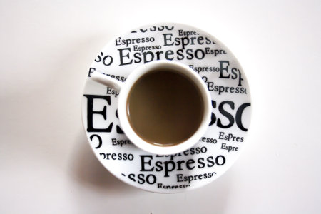 A top view of a cup of hot coffee on a white surfaceの写真素材