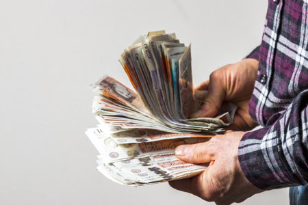 man counting money British sterling on a white backgroundの写真素材
