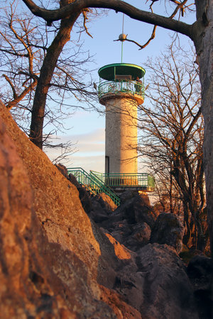 A view to the lookout tower Babi lom during golden sunset with the rock in front at Lelekovice, Czech republicの写真素材