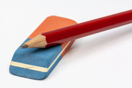 A closeup shot of rubber and a red pencil on a white background