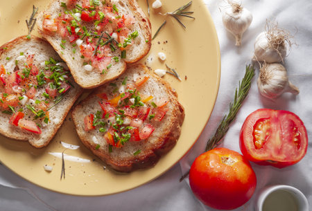 A background of a delicious sandwich divided into three parts with garlic, tomato, and rosemaryの写真素材