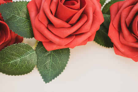 Artificial red roses isolated on light backgroundの写真素材