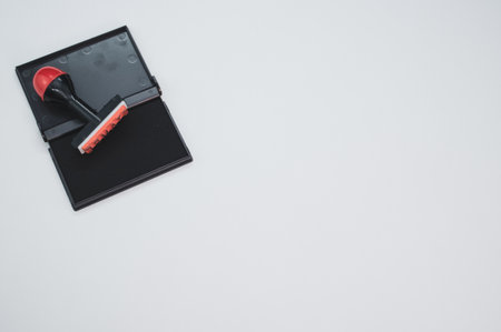 Black ink pad with stamp isolated on blue backgroundの写真素材