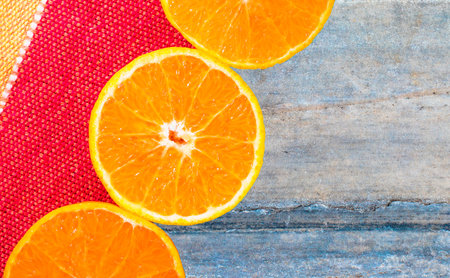 A top view of sliced juicy oranges on a brown marble rock surface - space for textの写真素材