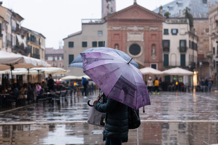 person with colorful umbrella walking on rainy dayの写真素材