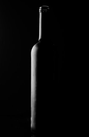 A minimalistic shot of a wine bottle silhouette on black backgroundの写真素材