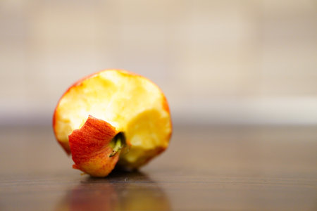 A selective focus closeup of a bitten apple on the tableの写真素材