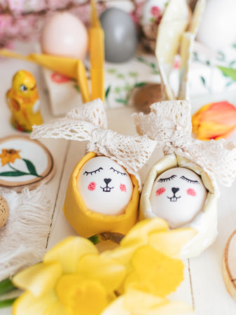 Easter decorations on white wooden background. Flowers, easter eggs, spring, holiday, celebration, easter bunny, yellow.の写真素材