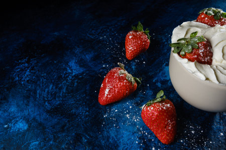 A closeup shot of delicious strawberries with sugar and creamの写真素材