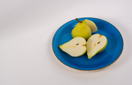 A closeup shot of green pears served on a blue plateの写真素材