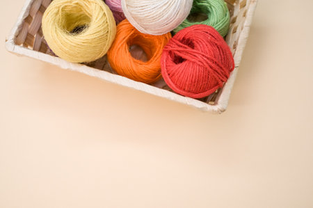 Colorful thread rolls in a box isolated on a beige backgroundの写真素材