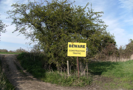 A sign on a dirt road in the woods warning about construction trafficの写真素材