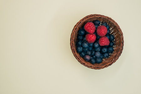A top view of blueberries and raspberries in a basketの写真素材