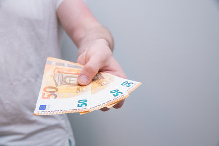 A closeup shot of a male holding cash money - finance concept