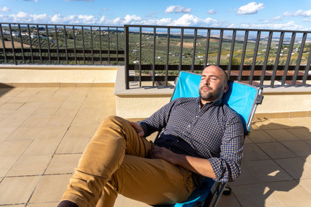 Stock photo of man resting and lying in a chair while enjoying sunny day.の写真素材